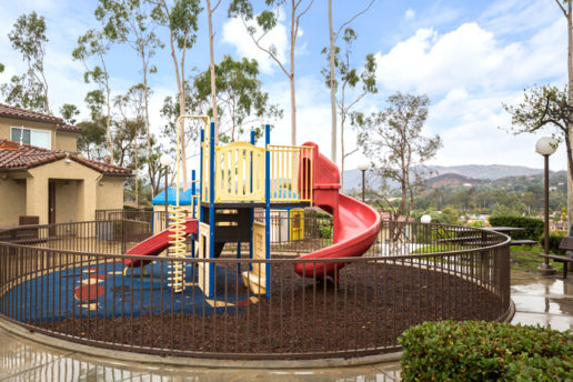 Children's playground with slide and various jungle gym equipment with view of mountains