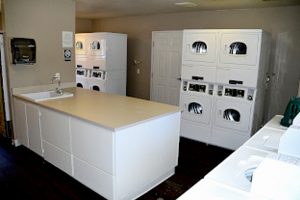 The Terraces laundry room with 11+ machines, an island in the middle of the room with a sink and paper towel dispenser